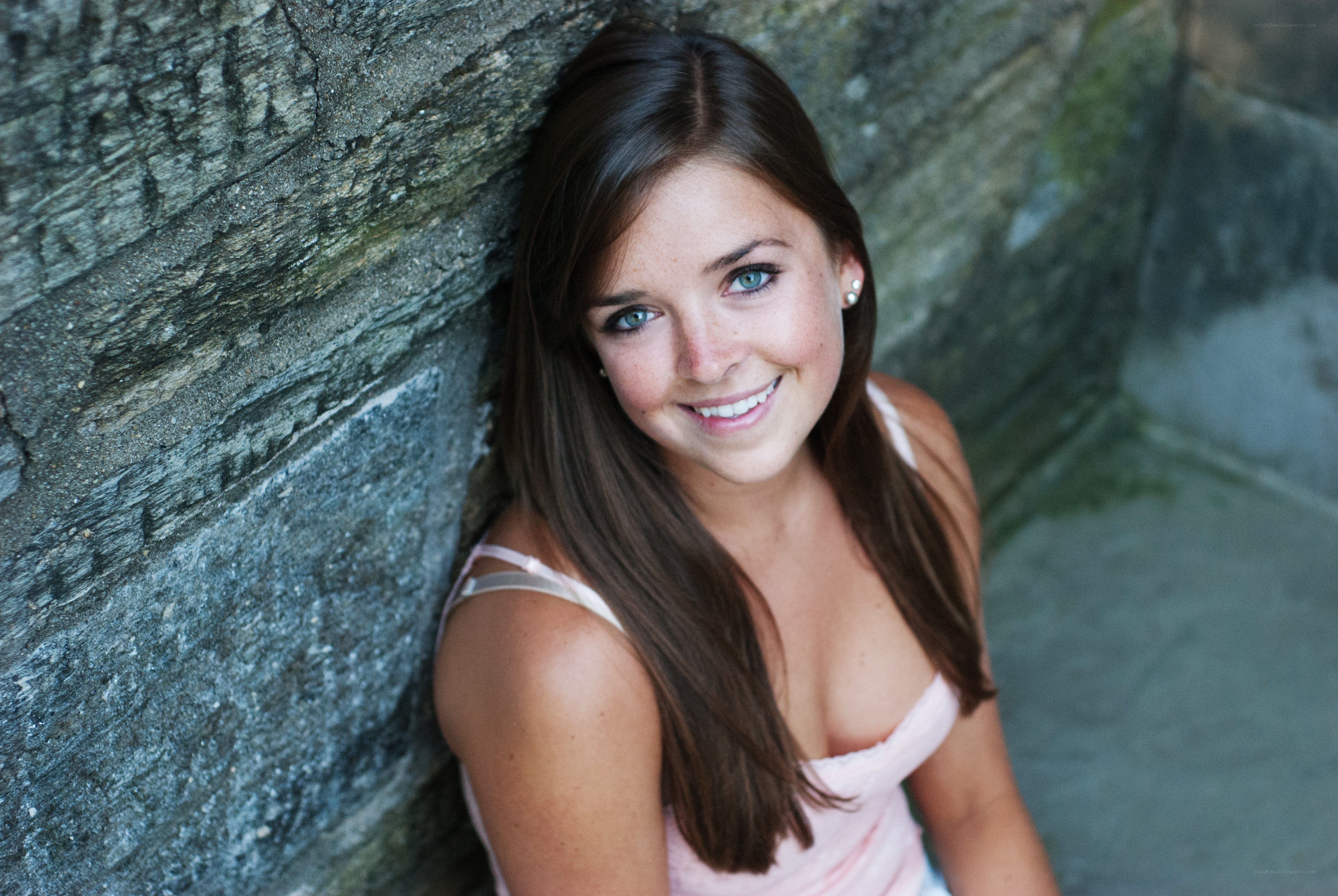 woman smiling by stone wall