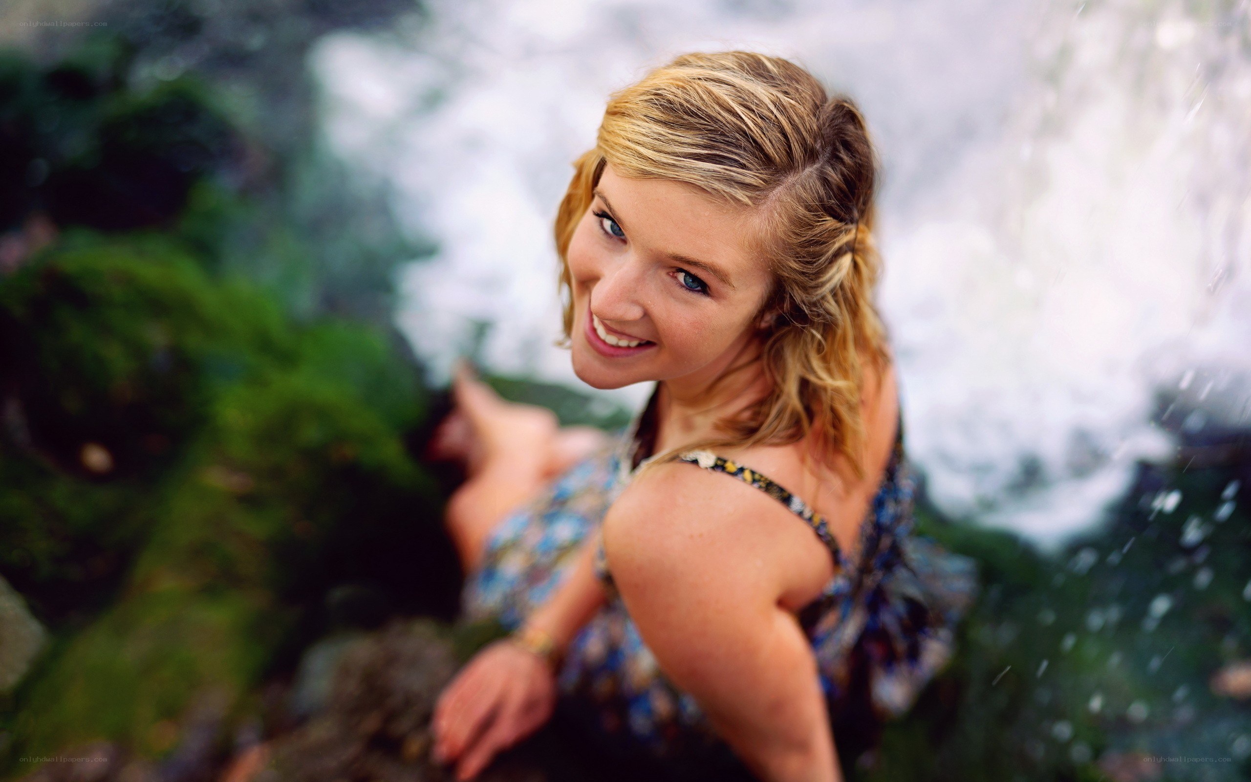 woman smiling by waterfall