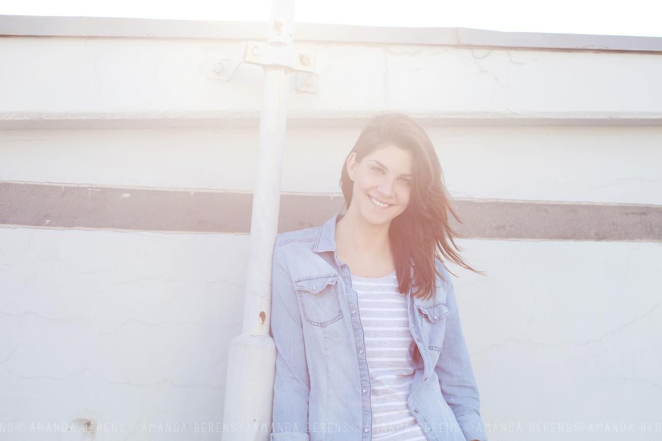 woman smiling by white wall