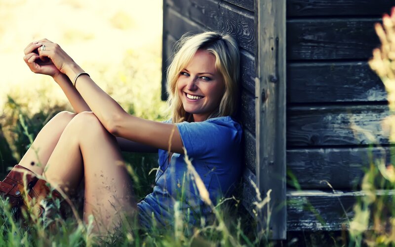 woman smiling by wooden wall