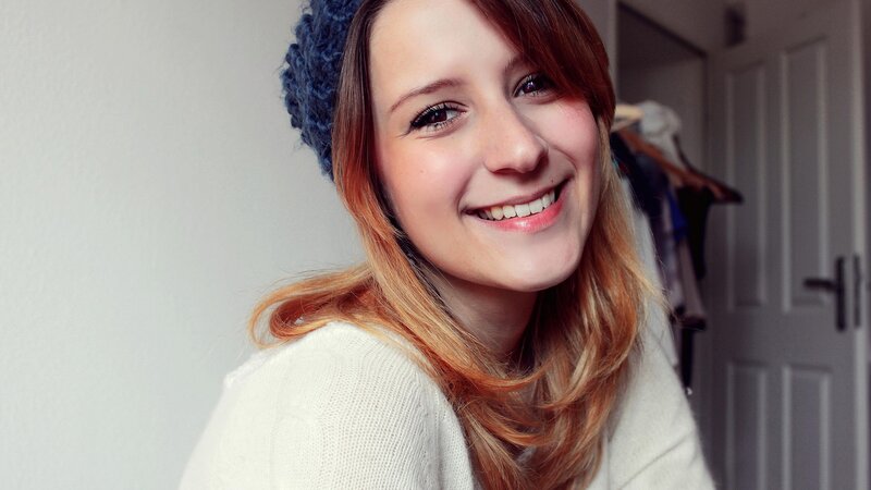woman smiling in a white sweater