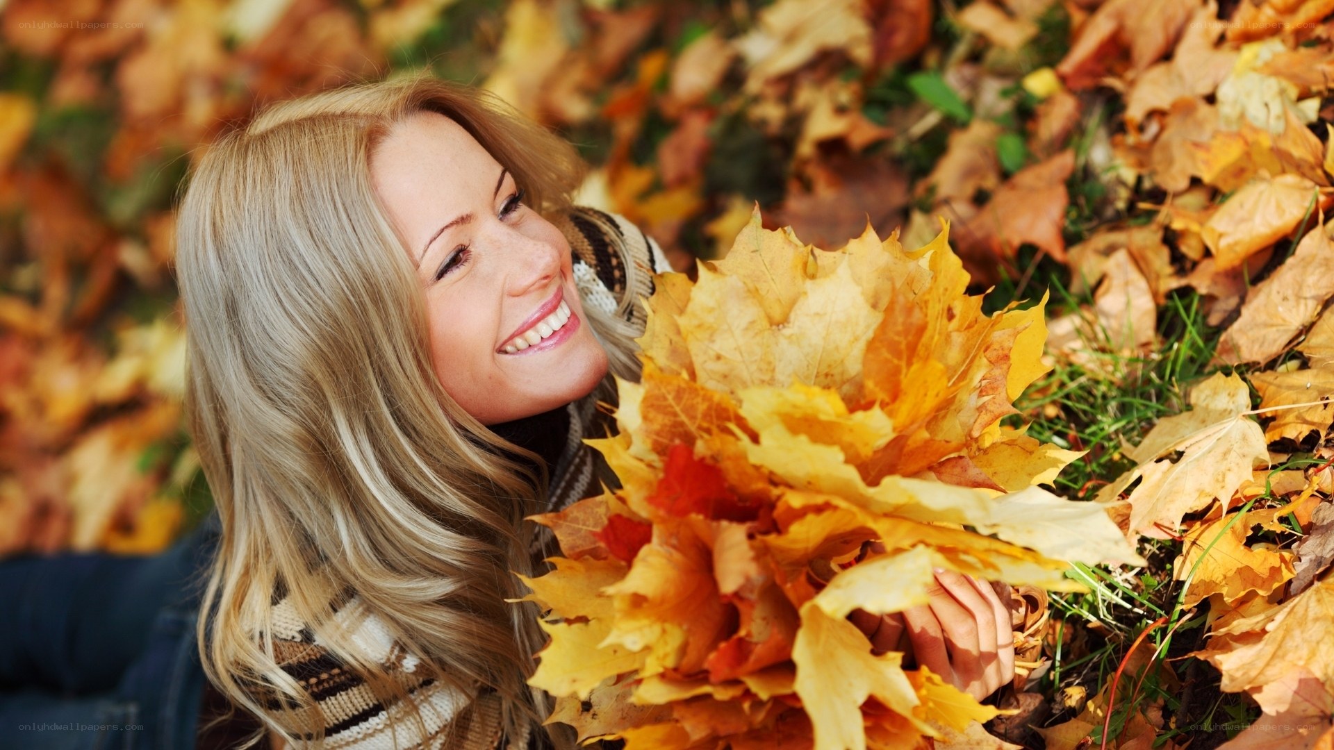 Woman smiling in autumn leaves