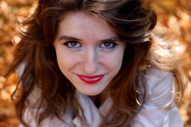 woman smiling in autumn leaves