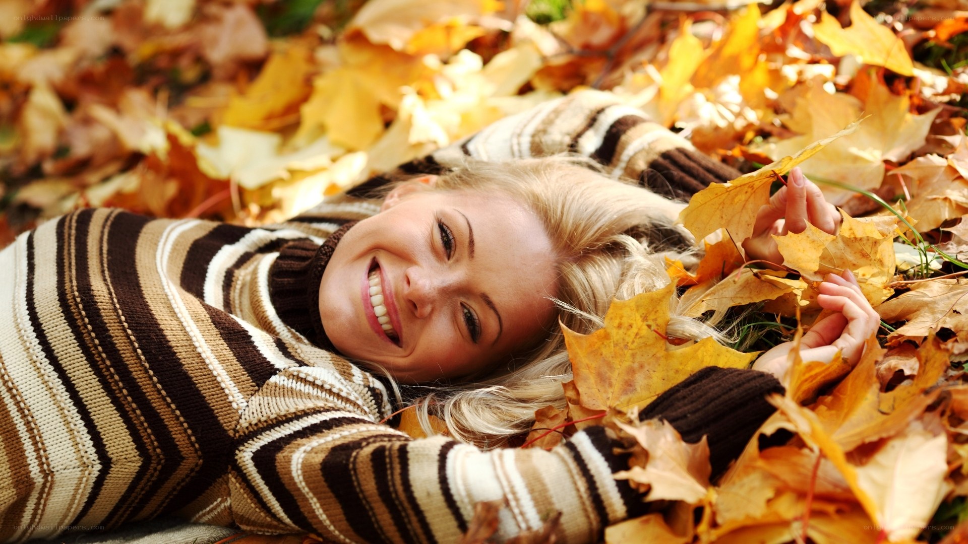 Woman smiling in autumn leaves