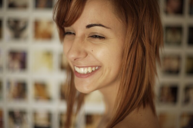 woman smiling in front of photo wall