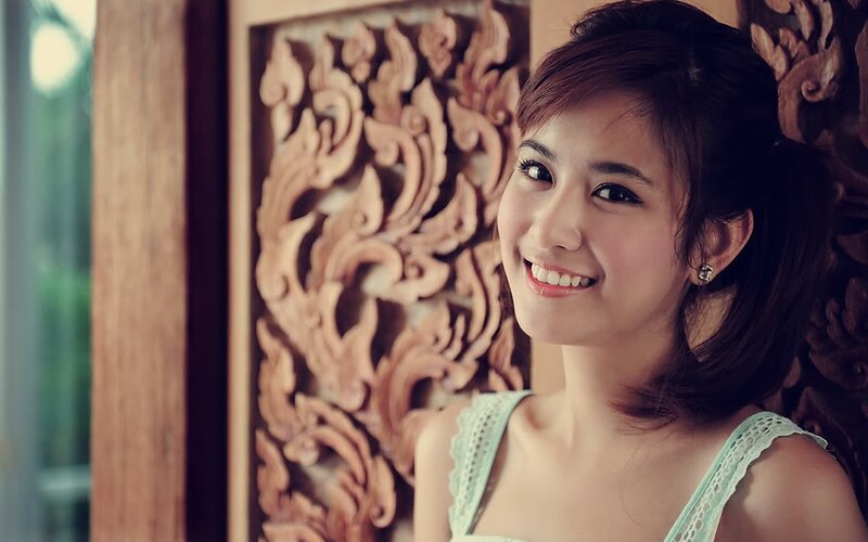 woman smiling in front of wood carving