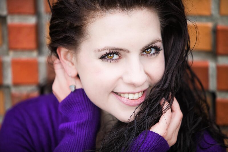 woman smiling in purple sweater