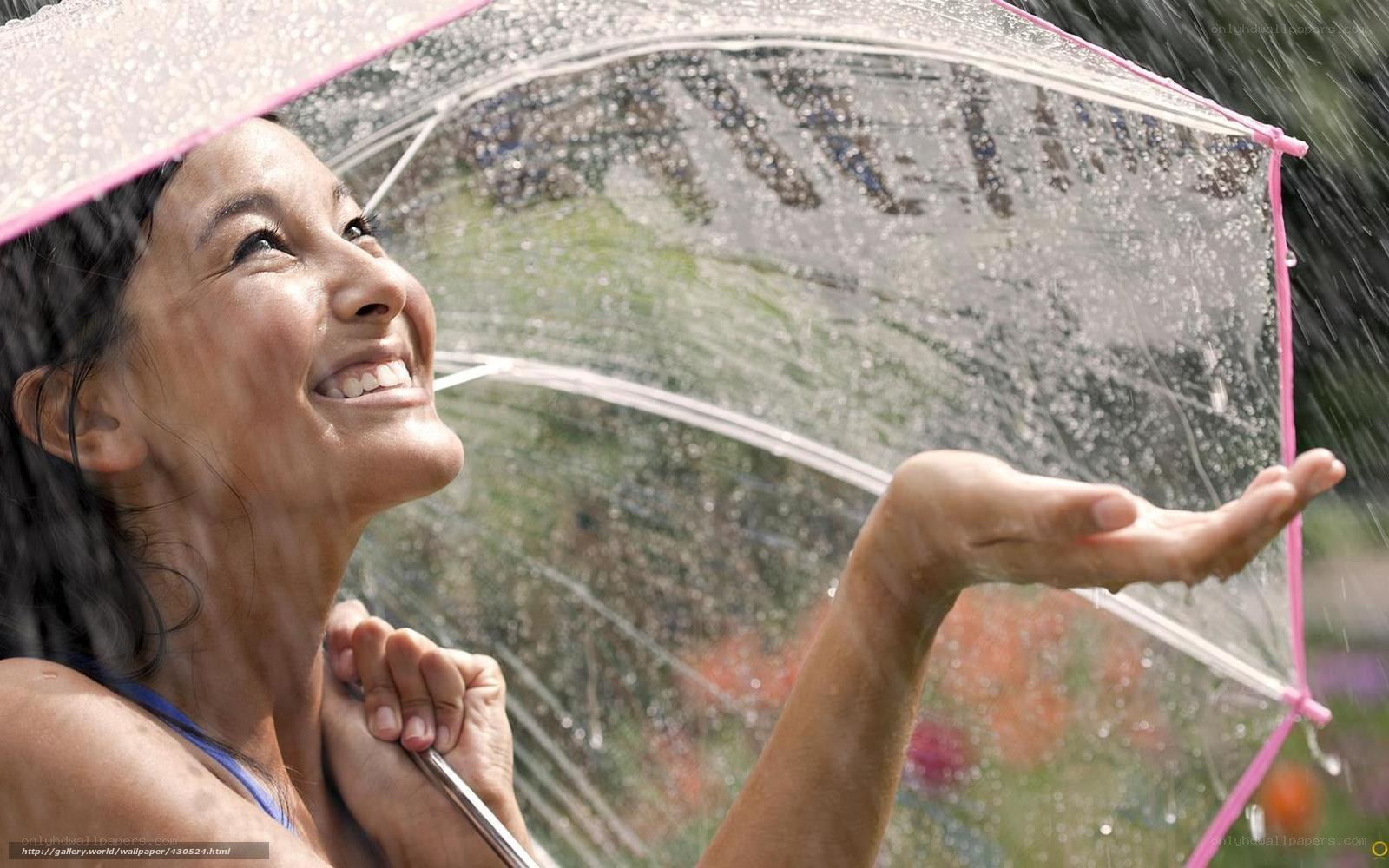 woman smiling in rain under umbrella