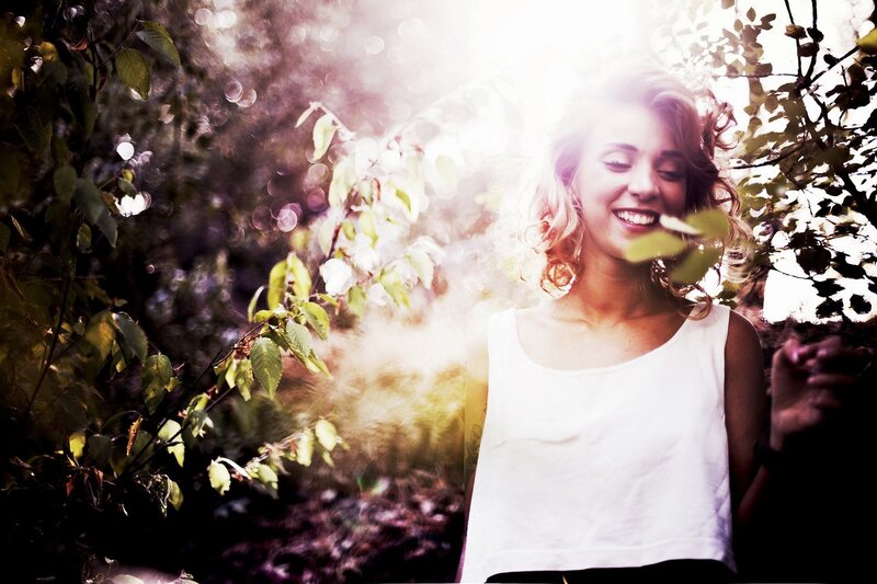 woman smiling in sunlit forest
