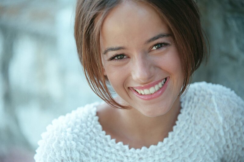 woman smiling in white sweater