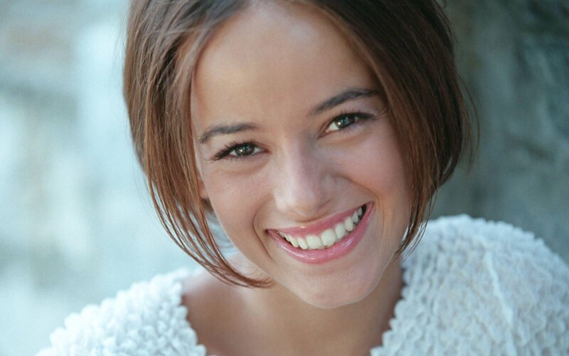 woman smiling in white sweater