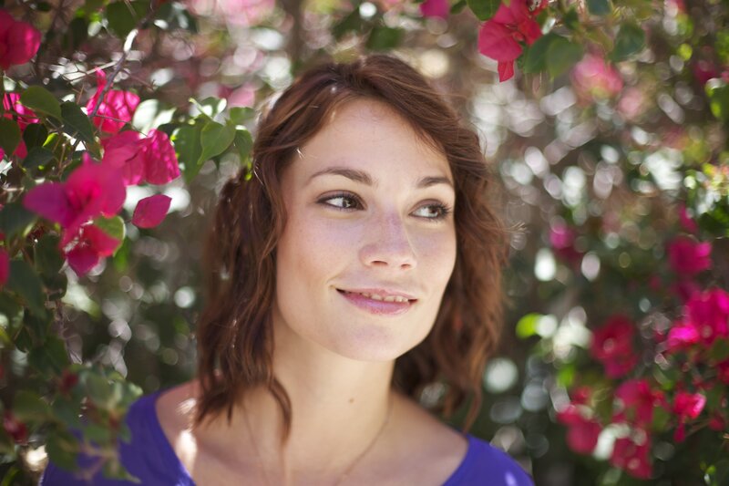 woman smiling near flowers