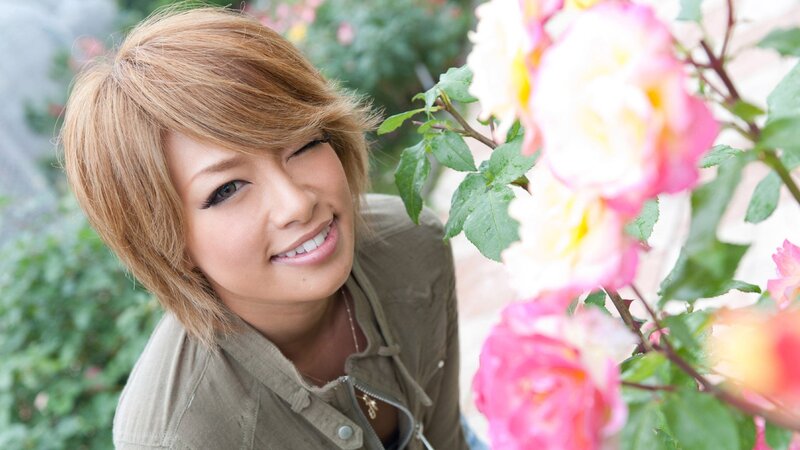 woman smiling near roses