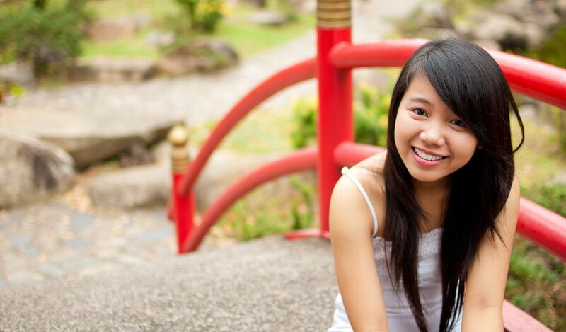 Woman smiling on a red bridge
