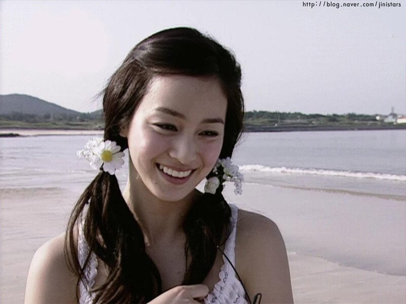 woman smiling on beach with flowers