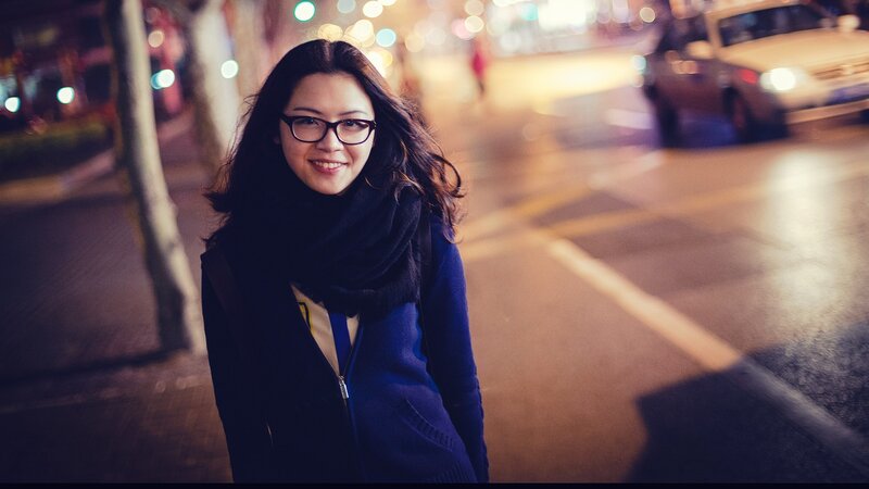 woman smiling on city street at night