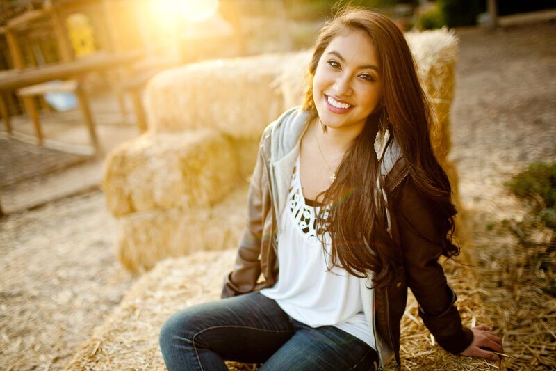 woman smiling on hay bale