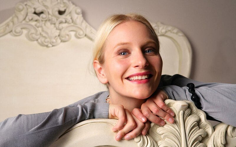 woman smiling on ornate chair