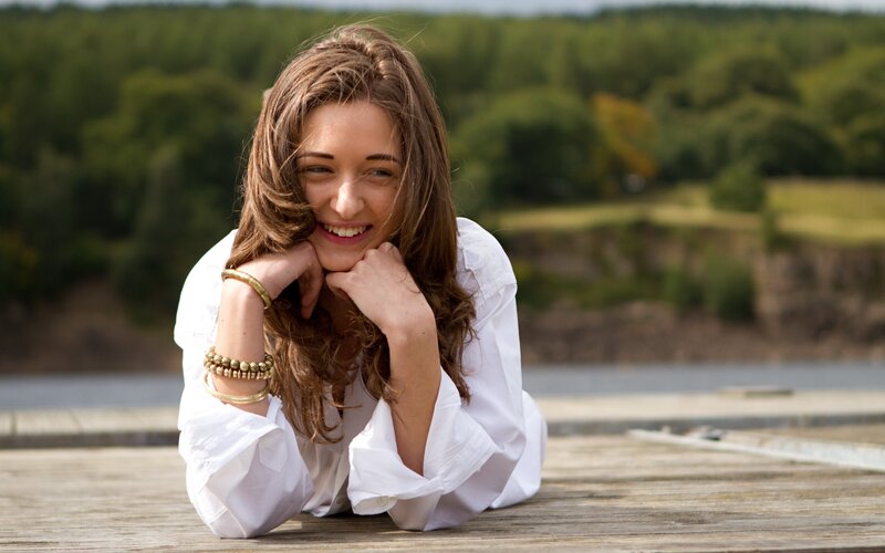 woman smiling on wooden deck