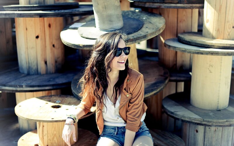 Woman smiling on wooden spools