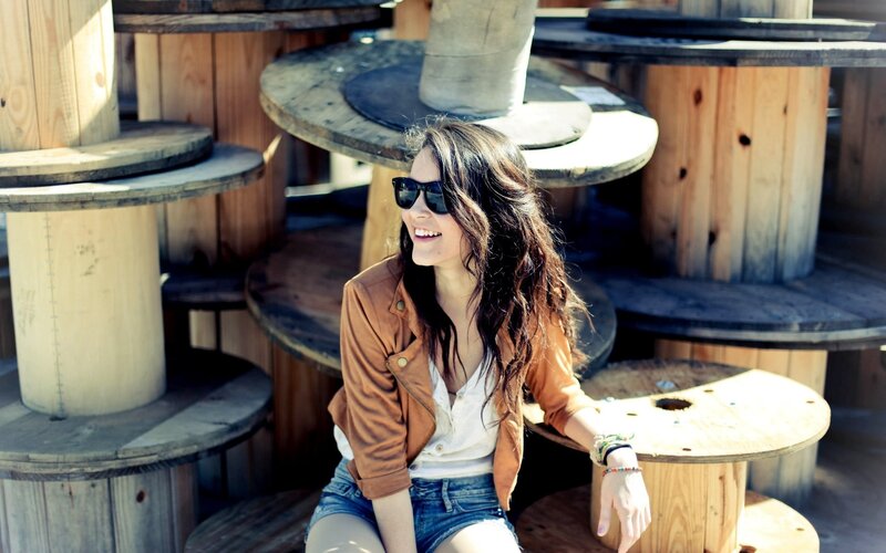 woman smiling on wooden spools