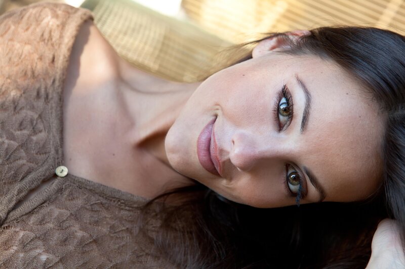 woman smiling on woven mat