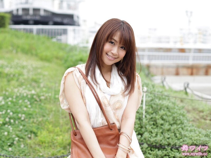 woman smiling outdoors with bag