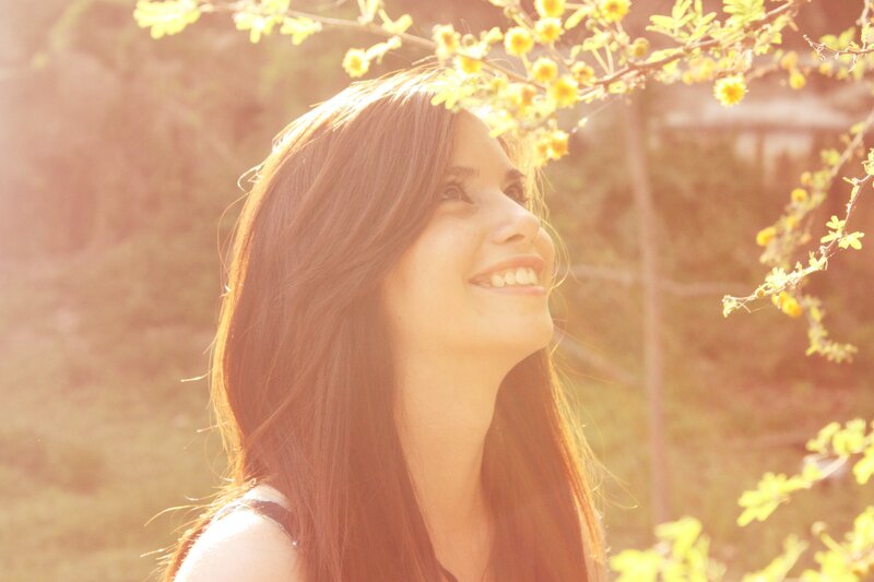 woman smiling under blossoms