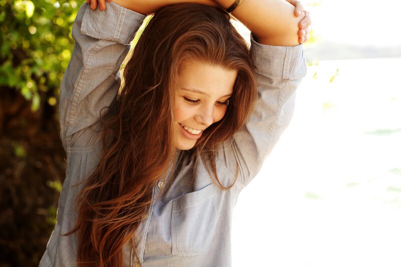 woman smiling with arms raised