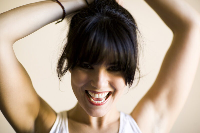 woman smiling with arms raised