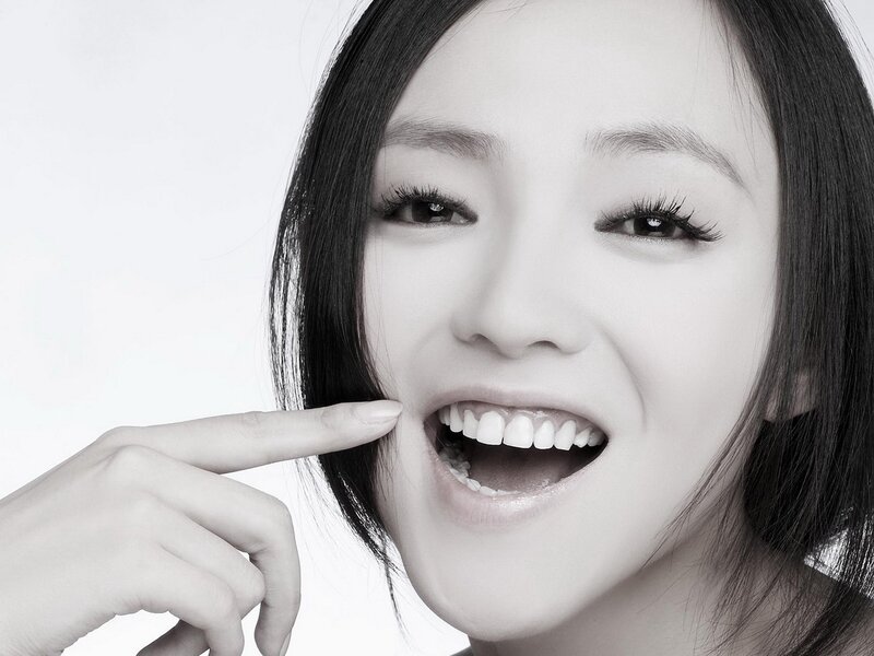 woman smiling with finger on cheek
