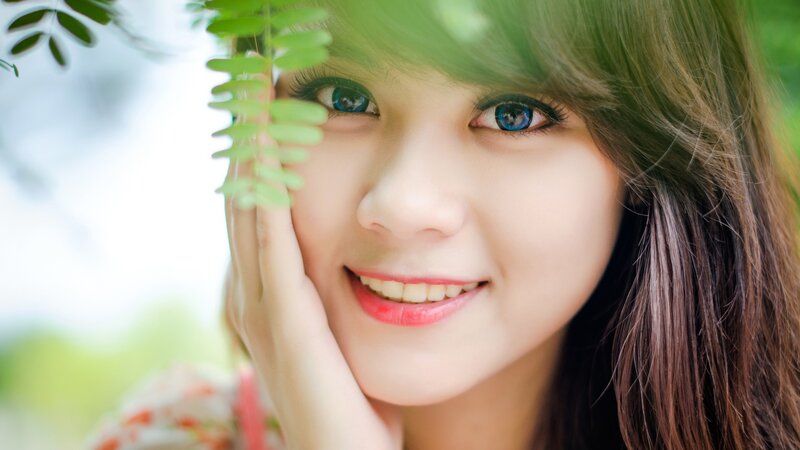 woman smiling with green leaves