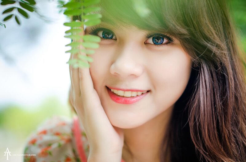 woman smiling with green leaves