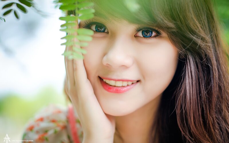 woman smiling with green leaves