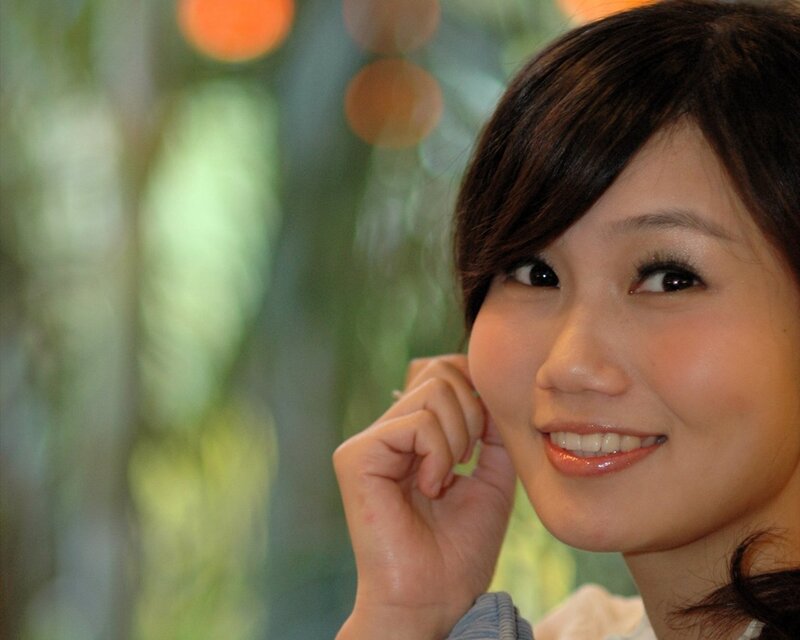 woman smiling with hand near face