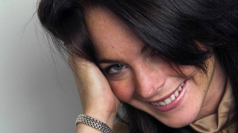 woman smiling with hand on cheek
