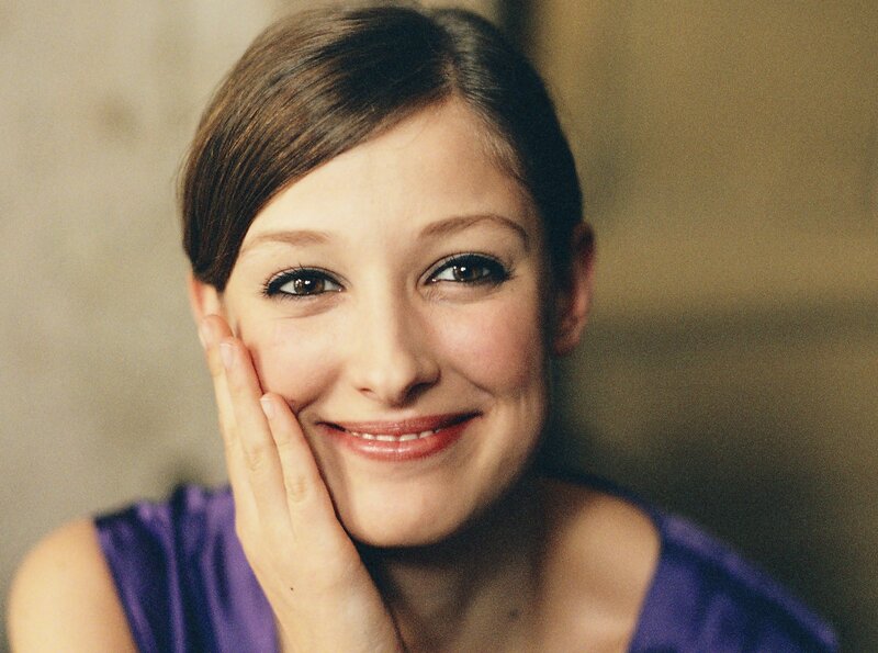 woman smiling with hand on cheek