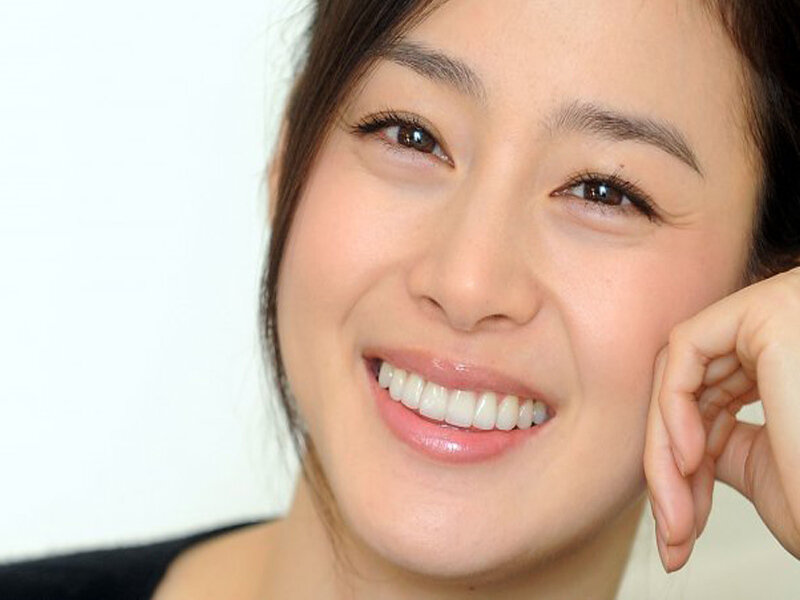 woman smiling with hand on cheek