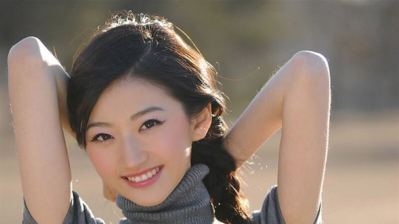 woman smiling with hands behind head