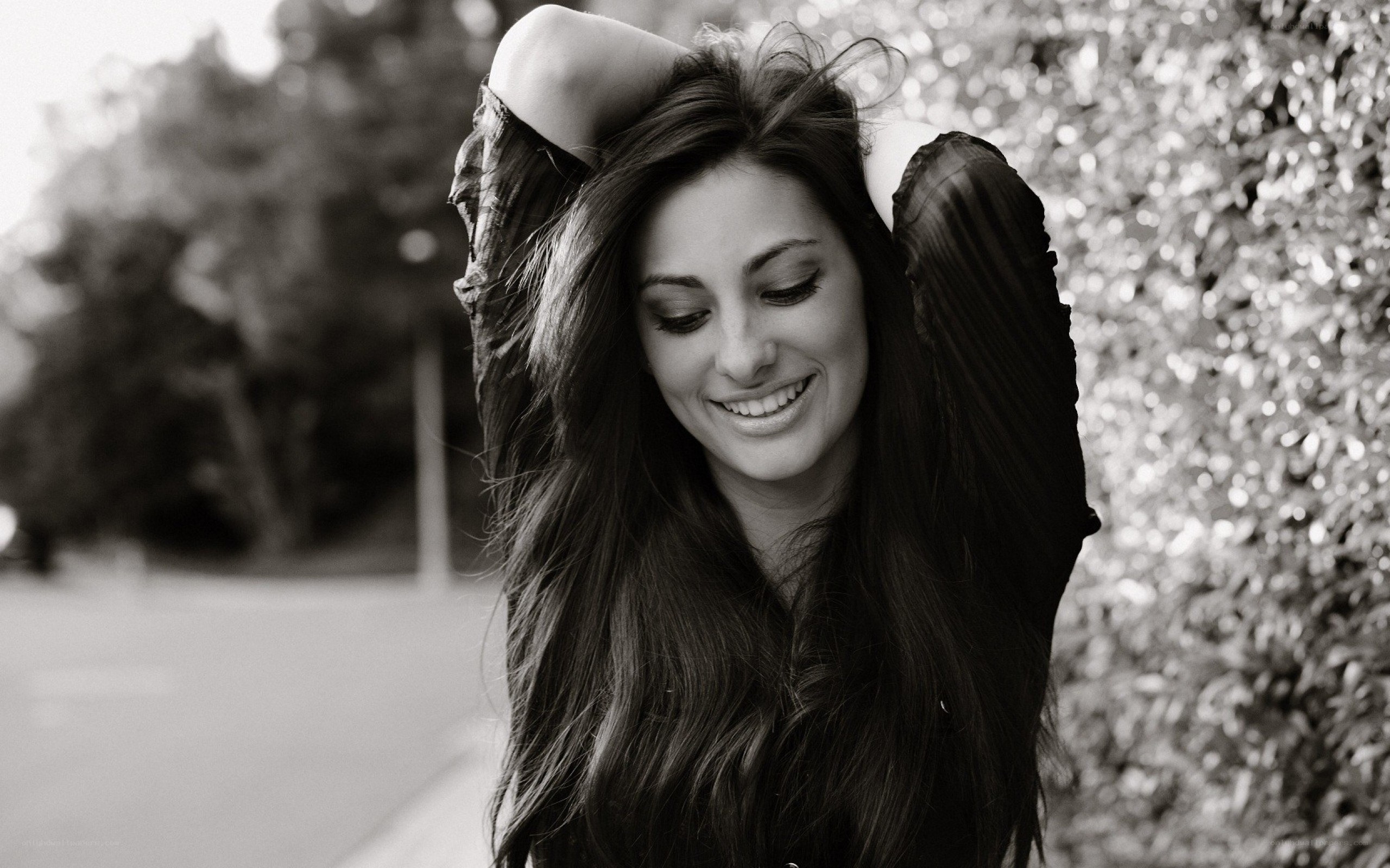 woman smiling with hands behind head