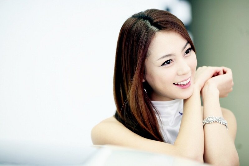 woman smiling with hands clasped