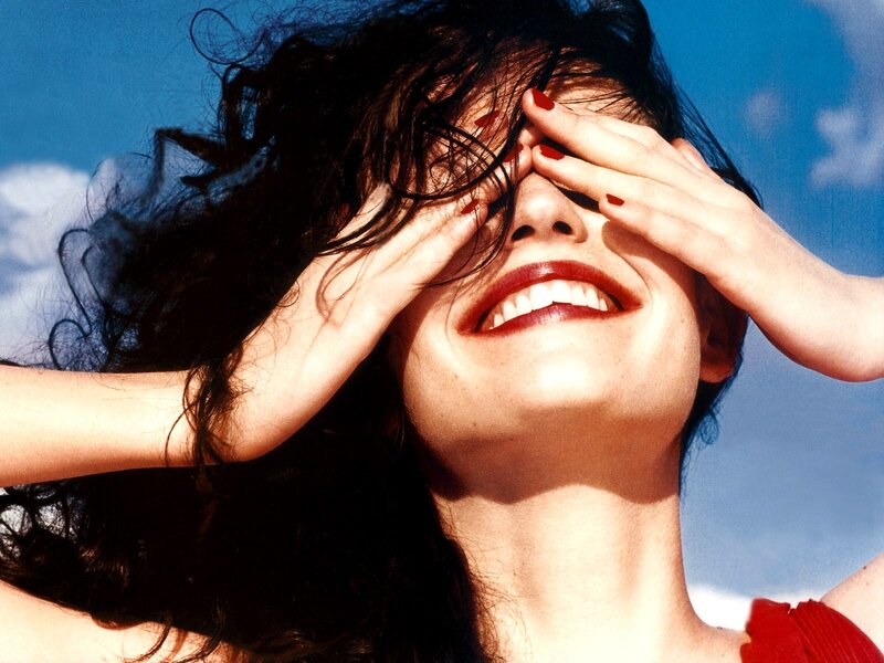 woman smiling with hands on face