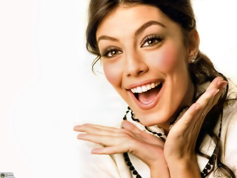 woman smiling with hands on face