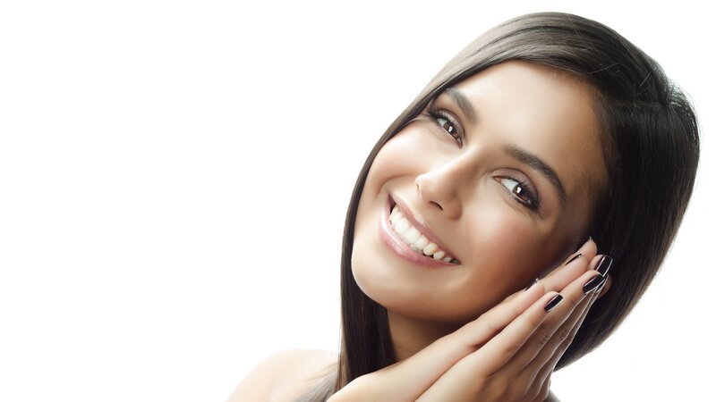 woman smiling with hands on face
