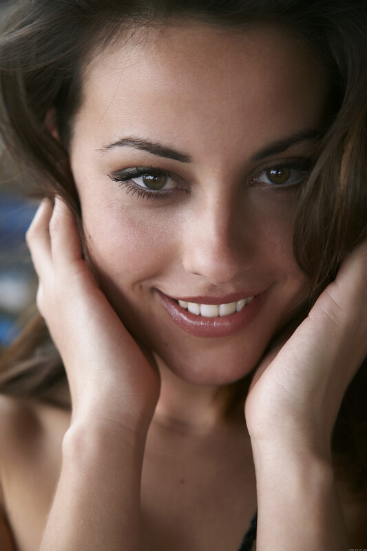 woman smiling with hands on face