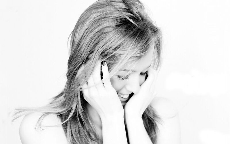 woman smiling with hands on face