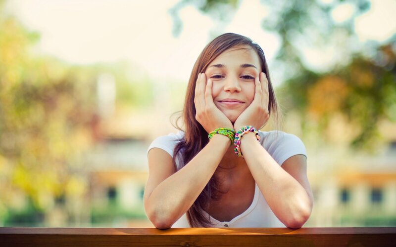 woman smiling with hands on face