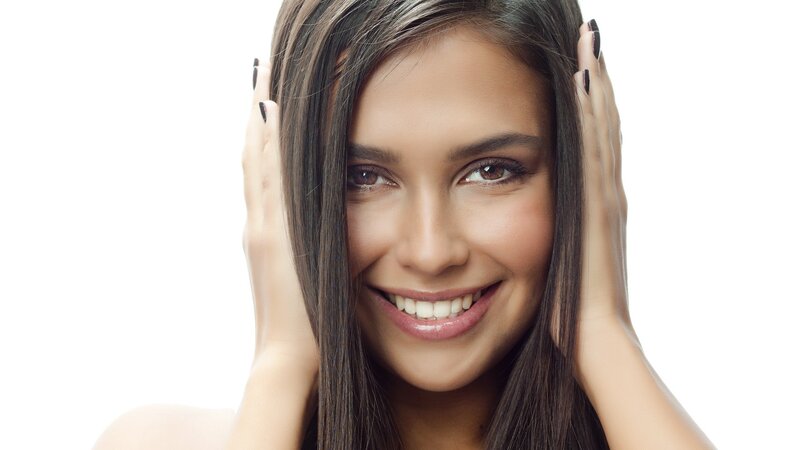 woman smiling with hands on head