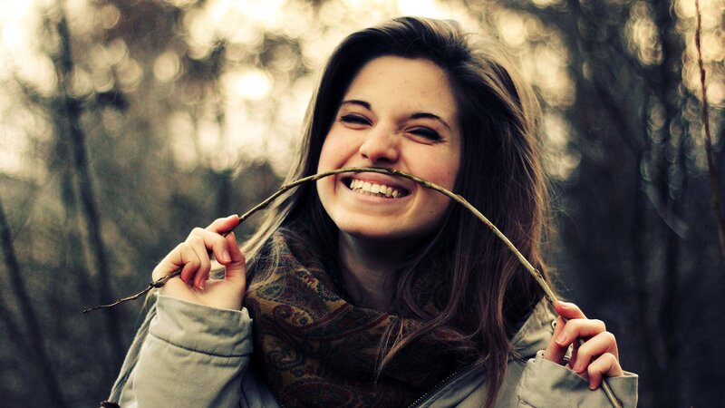woman smiling with stick in mouth