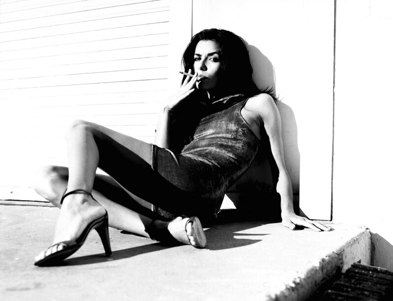 woman smoking against wall